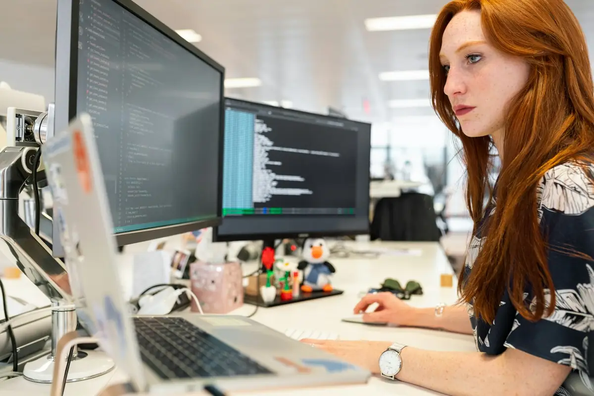 Engineer working across multiple monitors